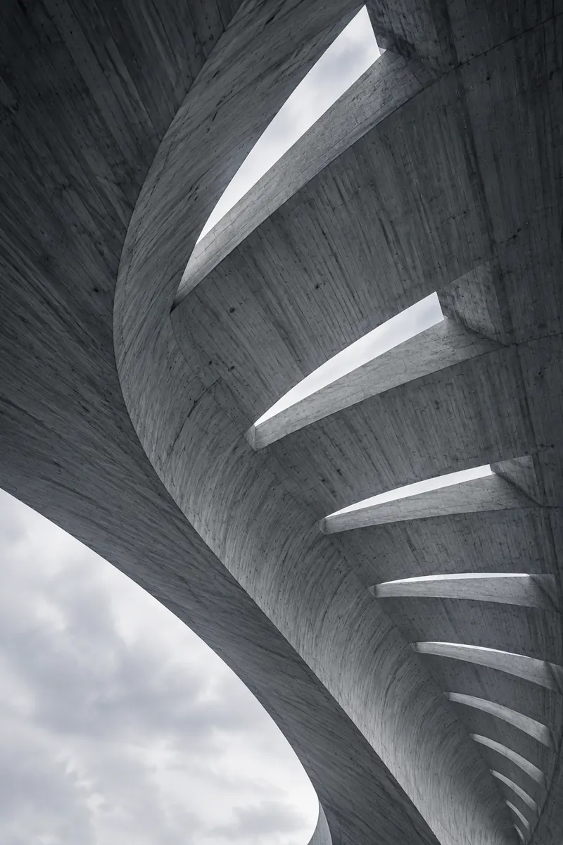 Underside of a thin concrete canopy with narrow skylights